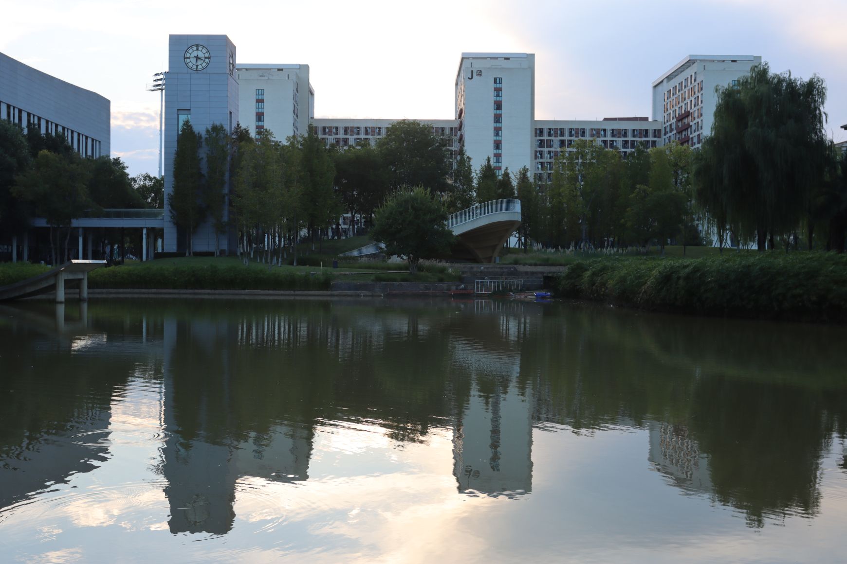 临水建筑群与白色弧形步行桥,黄昏水面倒影
