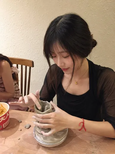 提示词：

以上传人物照片作为唯一身份与面部参考，生成一组真实自然的陶艺体验生活照。成年女性，长黑发